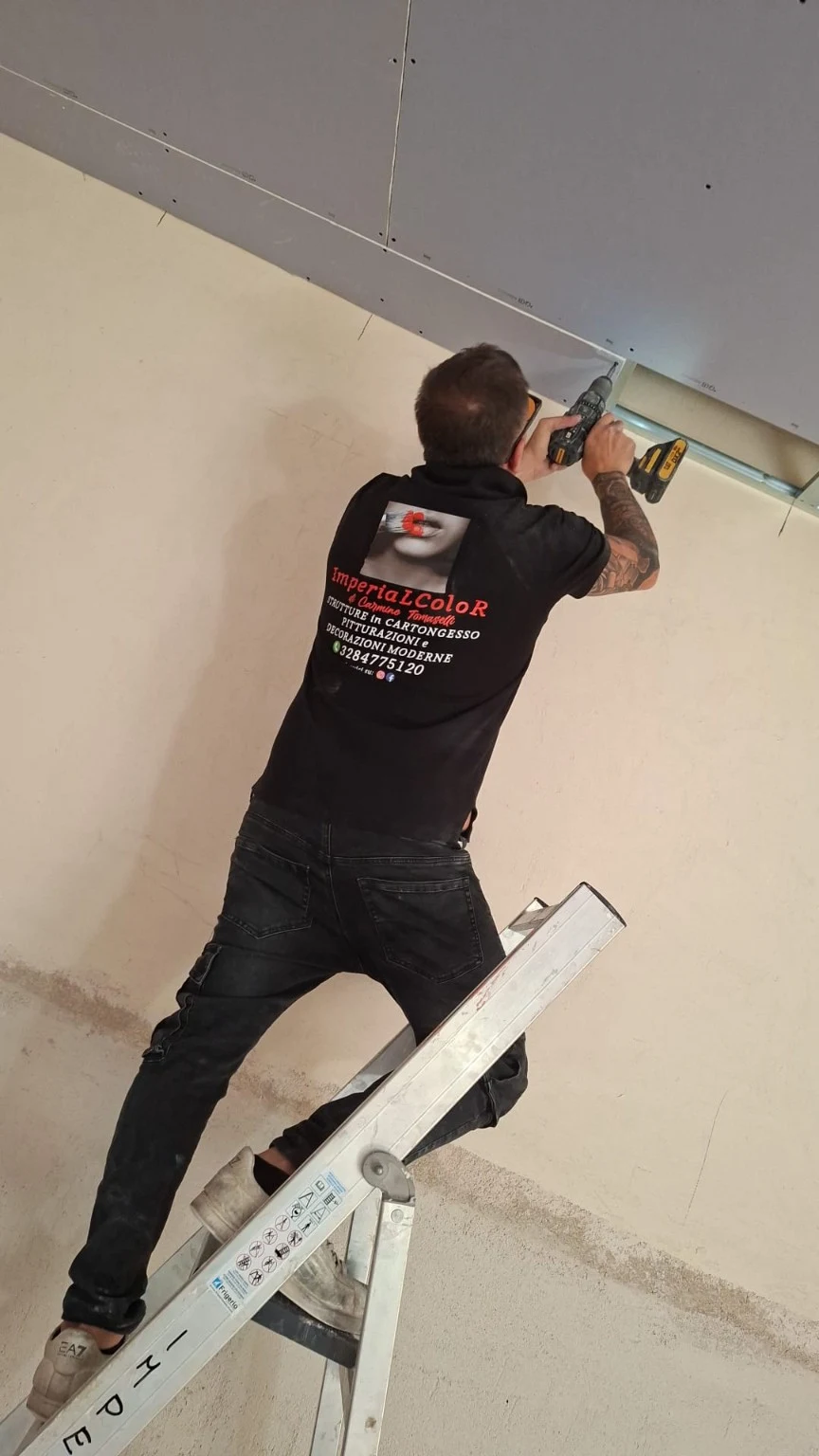 Posa di lastre in cartongesso con avvitatore e abbigliamento ImperiaLColoR
